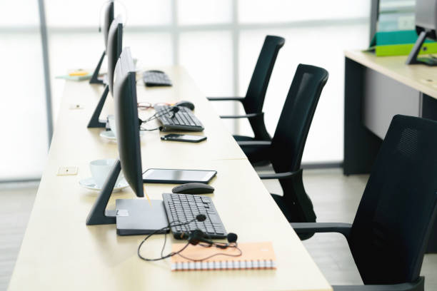 istock Chairs computers and headset call center in modern office 1212658654