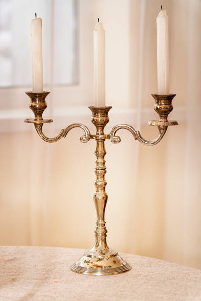 istock Antique gold candlestick with three candles on light background 1212658963