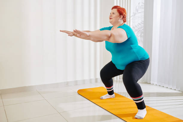istock Overweight woman doing squats 1212659898