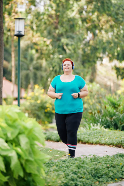 istock Jogging overweight woman 1212659958