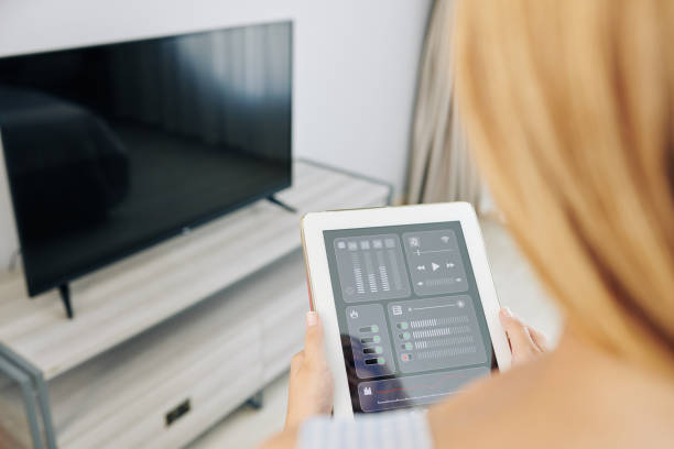 istock Woman controllingtv with mobile app 1212662109