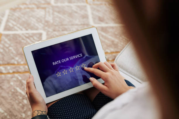 Woman rating online service Woman rating service and leaving feedback via application on tablet computer leaving a tip stock pictures, royalty-free photos & images
