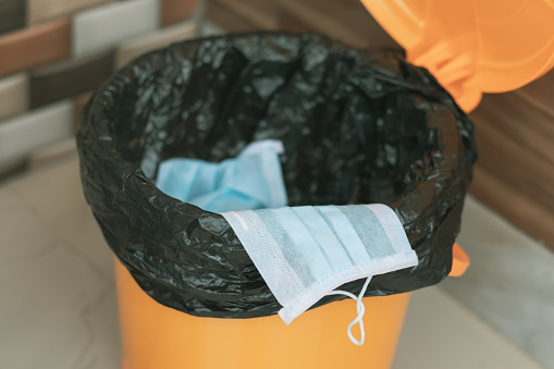 Covid-19, 2019-nCov or Coronavirus advice to discard or dispose the medical face mask to closed bin or trash can properly after usage - concept showing to do hygiene practice.
