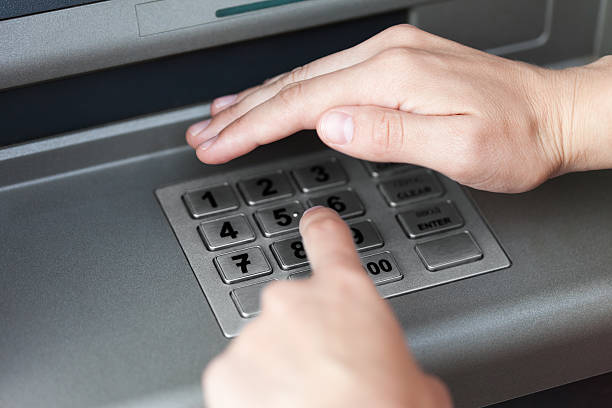 Entering atm cash machine pin code stock photo