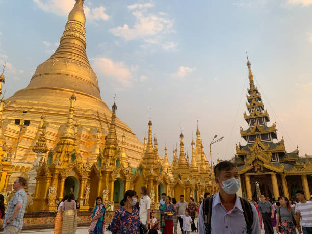 Yangon, Myanmar - March 1,2020 : Tourist visit Shwedagon Pagoda Yangon, Myanmar - March 1,2020 : Tourist visit Shwedagon Pagoda. Man with face mask on during a global corona virus pandemic. yangon photos stock pictures, royalty-free photos & images