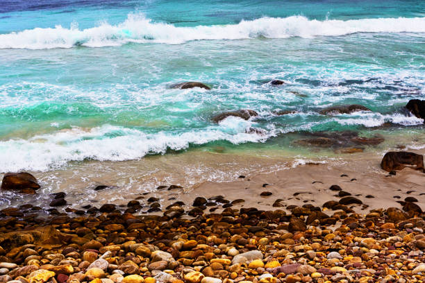Waves break onto a pebbly beach.