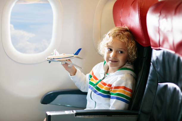 istock Child flying in airplane. Flight with kids. 1212667735