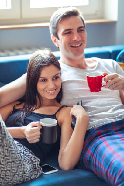 istock Young couple on the sofa watching funny program on TV 1212668033