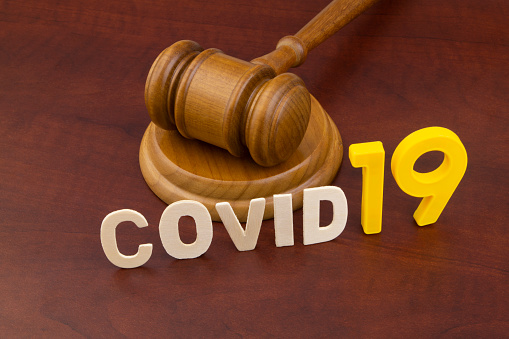 Wooden judge gavel with letters covid19. Concept of quarantine and law against covid-19.