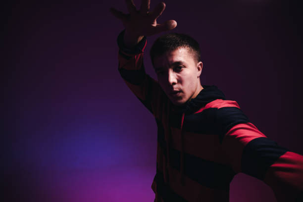 istock Young Man in a Jumper Dancing Contemporary Dance in Studio. Breakdancing. Dance School Poster. Copy Space. Battle competition announcement. Pink and Blue Background. 1212668764