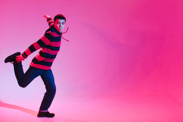 istock Young Man in a Jumper Dancing Contemporary Dance in Studio. Breakdancing. Dance School Poster. Copy Space. Battle competition announcement. Pink and Blue Background. 1212669166