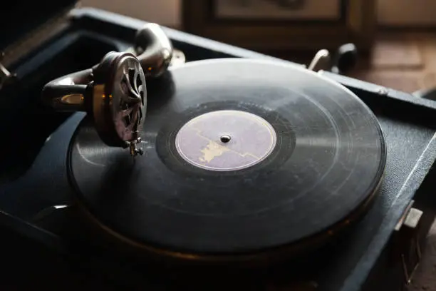 Vintage vinyl record playing on an old grungy black photograph