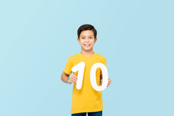 istock Handsome 10 year-old mixed race boy smiling and holding numbers isolated on light blue backround 1212677208