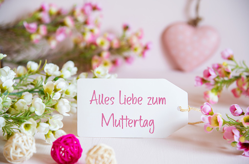 Label With German Text Alles Liebe Zum Muttertag Means Happy Mothers Day. Rose And White Flowers With Heart Decoration.