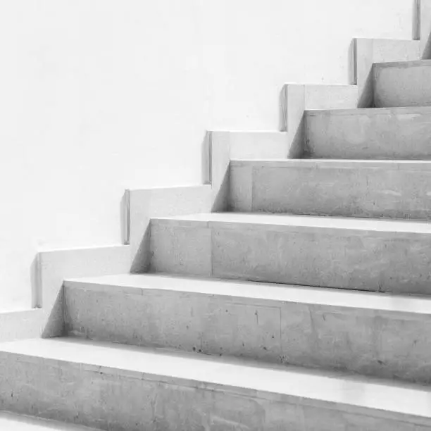 Photo of Empty white stone stairway near white wall