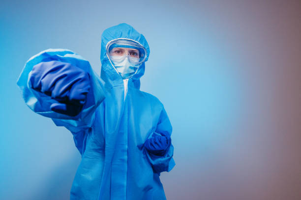 istock Virus. A paramedic in a protective suit against the virus punches the air. 1212678099