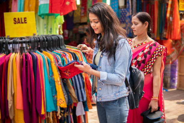 madre e hija comprando ropa juntos en el mercado callejero al aire libre. - india indian culture women market fotografías e imágenes de stock