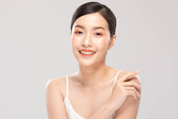 istock Beautiful Young Asian Woman Looking While Touching Shoulder feeling so happy and cheerful with healthy Clean and Fresh skin,isolated on white background,Beauty Cosmetology Concept 1212679633