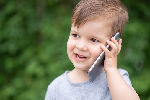 the child speaks on the phone in nature
