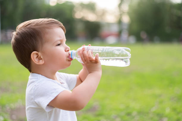 istock child drinks water from a bottle on a hot summer day 1212682774