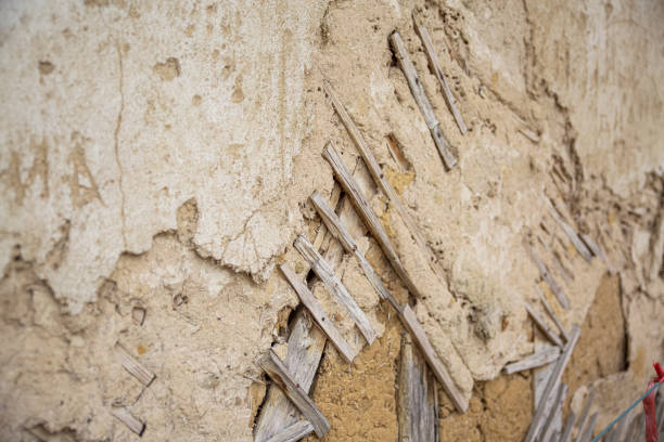 Close up of cracked adobe wall texture, clay wall from a mud house in Bulgarian Village.