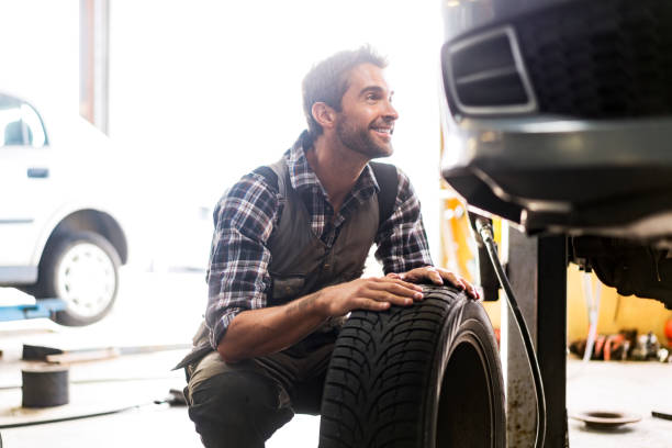 istock Confident mechanic fixing tire of car 1212689361
