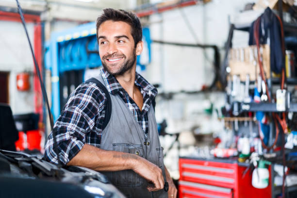 istock Smiling handsome repairman at garage 1212689409