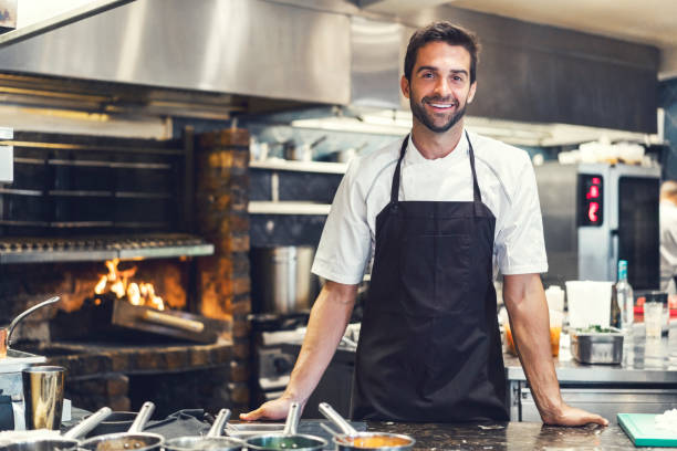 chef maschio fiducioso nella cucina commerciale - grembiule foto e immagini stock