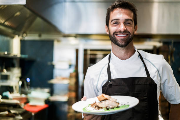 istock Smiling male chef with prepared dish in restaurant 1212691017