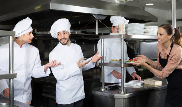 istock Staff of restaurant with glad chef in kitchen 1212693380