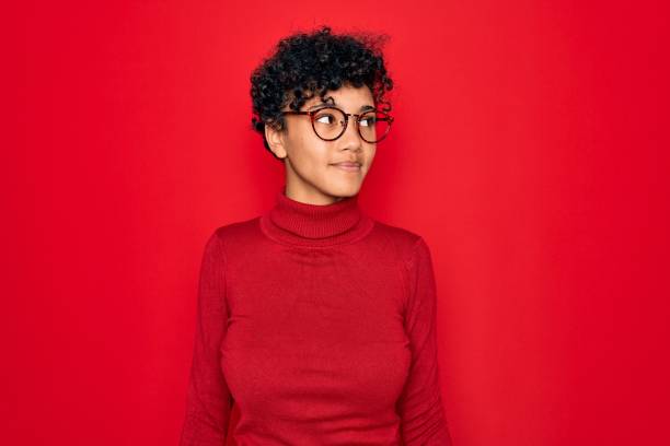 young beautiful african american afro woman wearing turtleneck sweater and glasses smiling looking to the side and staring away thinking. - mannered imagens e fotografias de stock