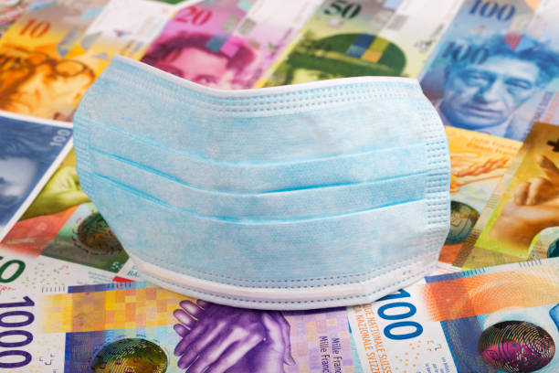 maska ochronna na szwajcarskim tle pieniędzy - swiss currency franc sign switzerland currency zdjęcia i obrazy z banku zdjęć