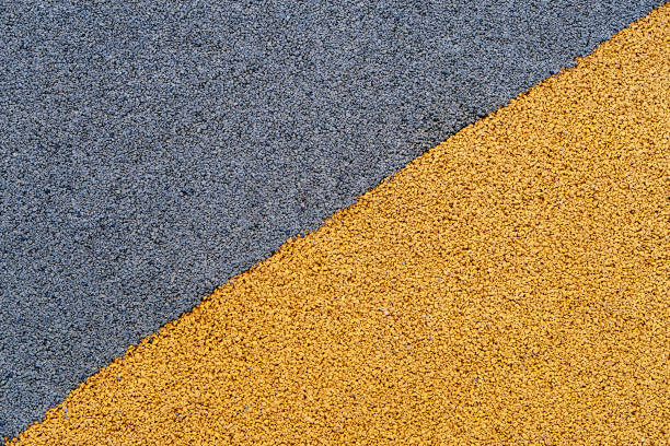 Bright diagonal yellow and black crumb rubber coating background. Safe, soft protective coating for stadiums and playgrounds