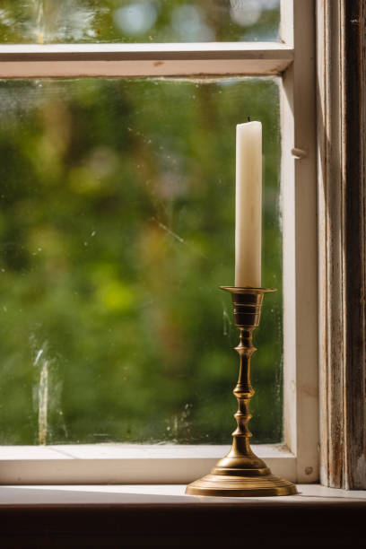 istock Old vintage window and vertical candle in candlestick 1212694752