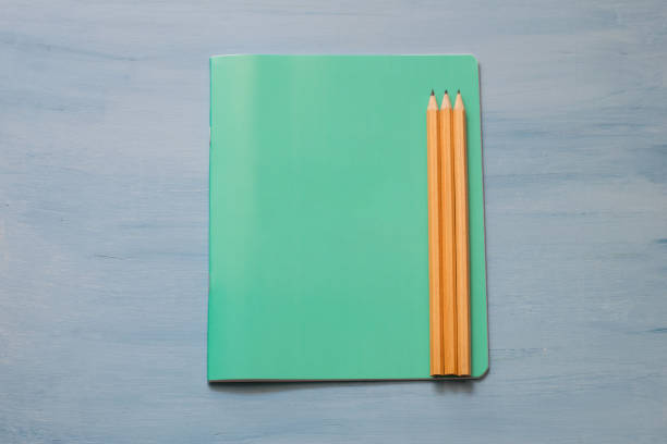 Top view of blank paper with pencils. Pencils on a notebook sheet.