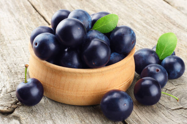 istock blackthorn berries with green leaf on old wooden table 1212697313