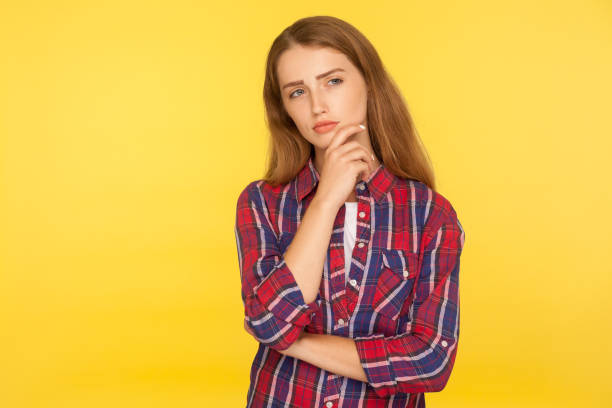 let me think. portrait of thoughtful ginger girl in checkered shirt standing with pensive look, pondering and musing - pensive question mark teenager adversity imagens e fotografias de stock