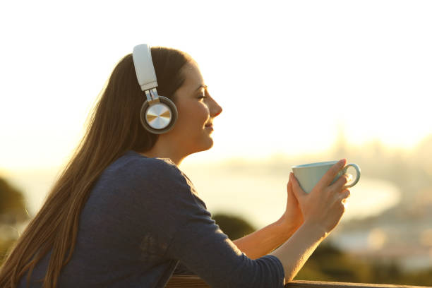 fille se relaxant avec une tasse de café écoutant la musique avec les yeux fermés - beach on child the photos et images de collection