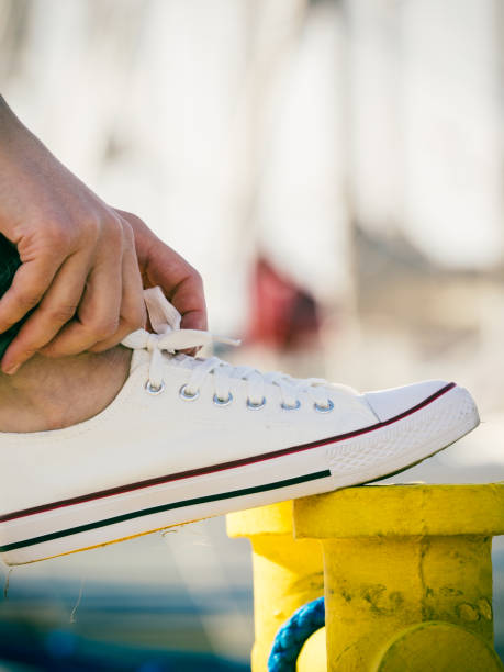 istock Woman tying shoes, white sneakers 1212698521