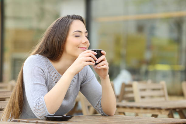 istock Satisfied woman smelling her coffee on a terrace 1212698608