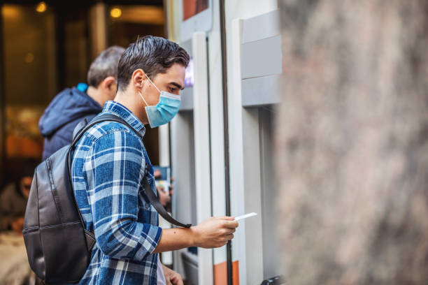 Man using an cash dispenser on the street