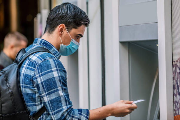 istock Man using a credit card in an atm for cash withdrawal 1212698919