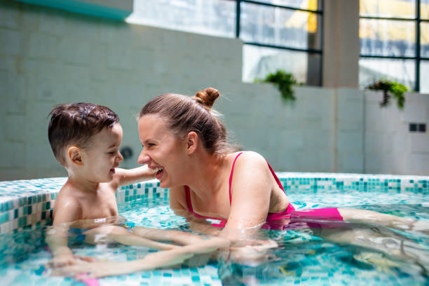 istock Mother playing with her son in the pool 1212701222
