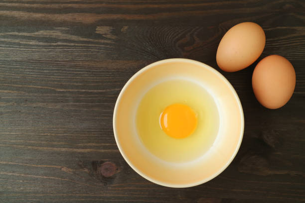 istock Top view of fresh raw egg in a bowl on wooden table 1212701254