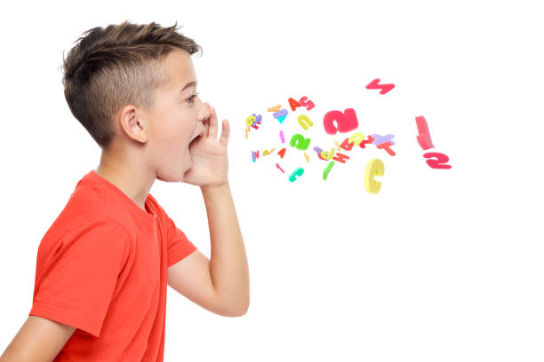 Young boy in bright red T-shirt shouting out alphabet letters. Speech therapy concept over white background. stock photo