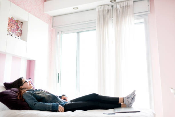 istock Young woman relaxing in her bedroom 1212703088