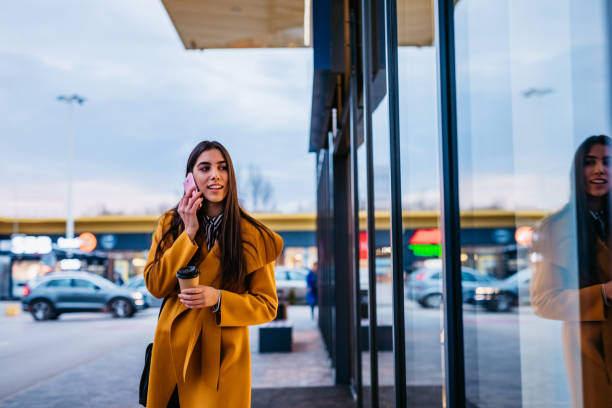 istock Woman talking on phone and window shopping 1212704589