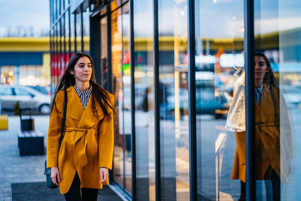 istock Young woman window shopping downtown 1212704999