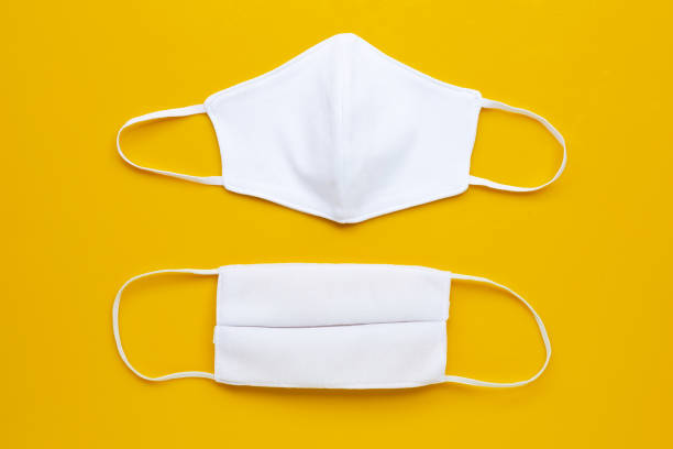 istock Handmade white cloth masks on cream yellow background. 1212705289