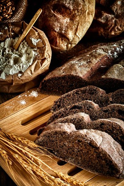 кустарная пекарня: закваска хлеб и разнообразие продуктов булочки - soda bread bread brown bread loaf of bread стоковые фото и изображения